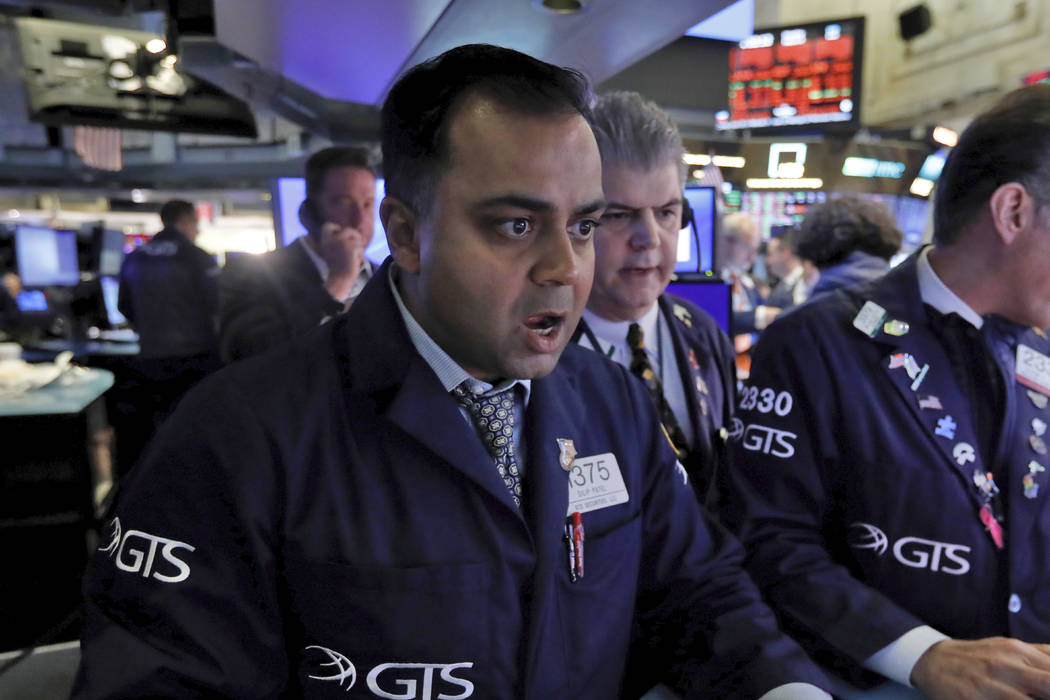 Specialist Dilip Patel, left, works at his post on the floor of the New York Stock Exchange, Mo ...