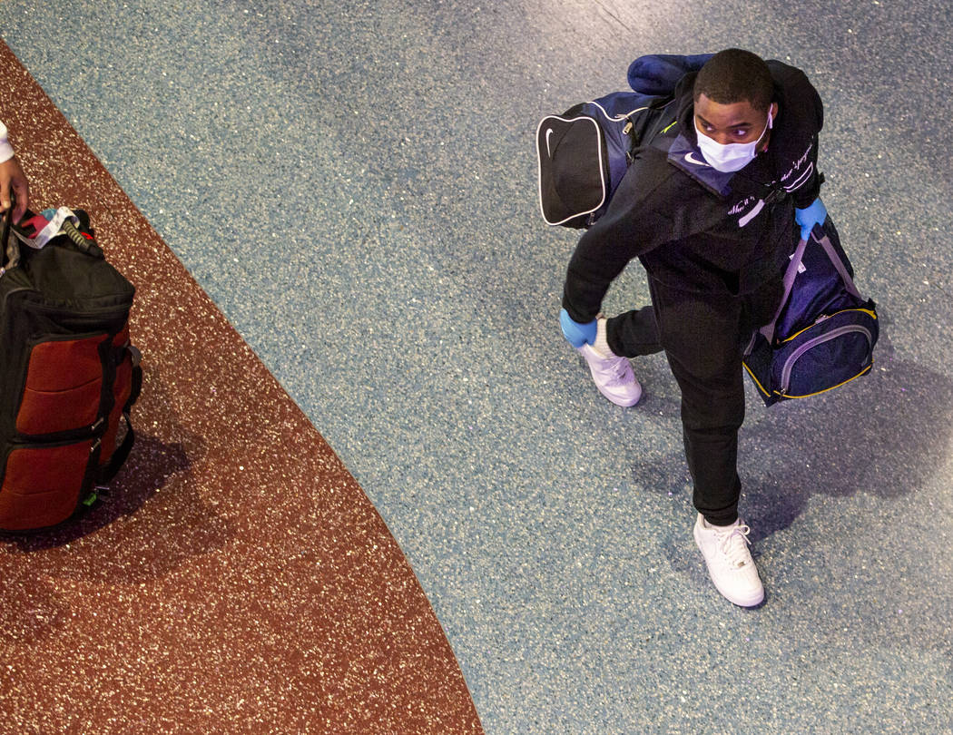 A passenger wears a face mask while walking through the Terminal 1 baggage claim in McCarran In ...