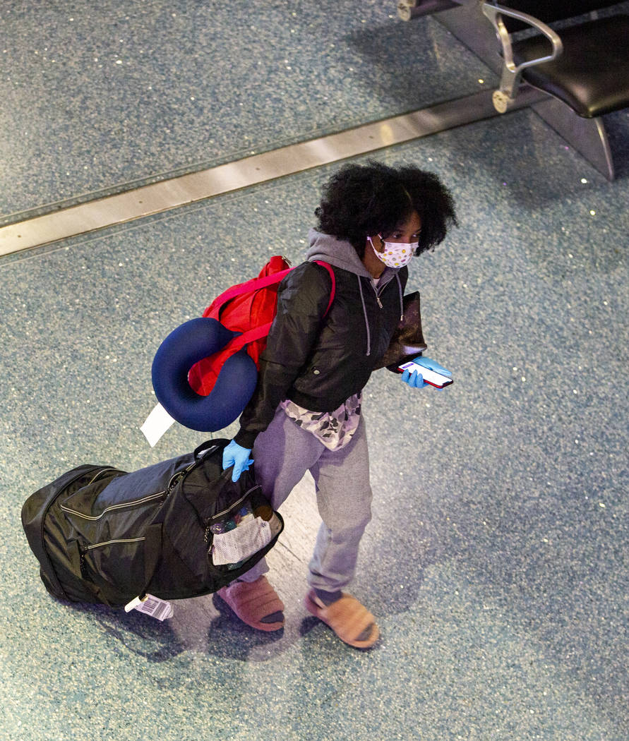 A passenger wears a face mask while walking through the Terminal 1 baggage claim in McCarran In ...