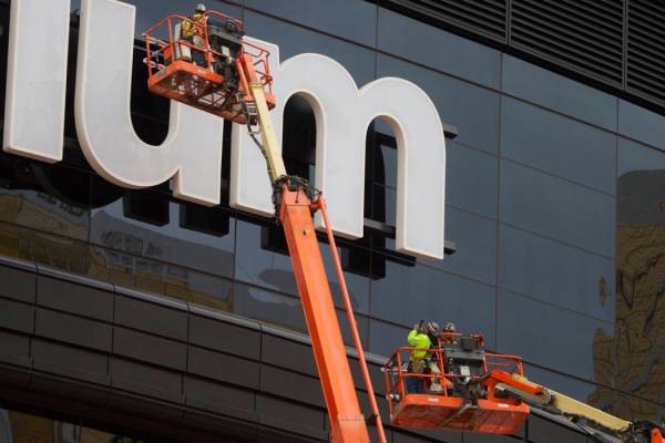 A worker takes a photo after helping install the last letter in the signage for the Raiders All ...