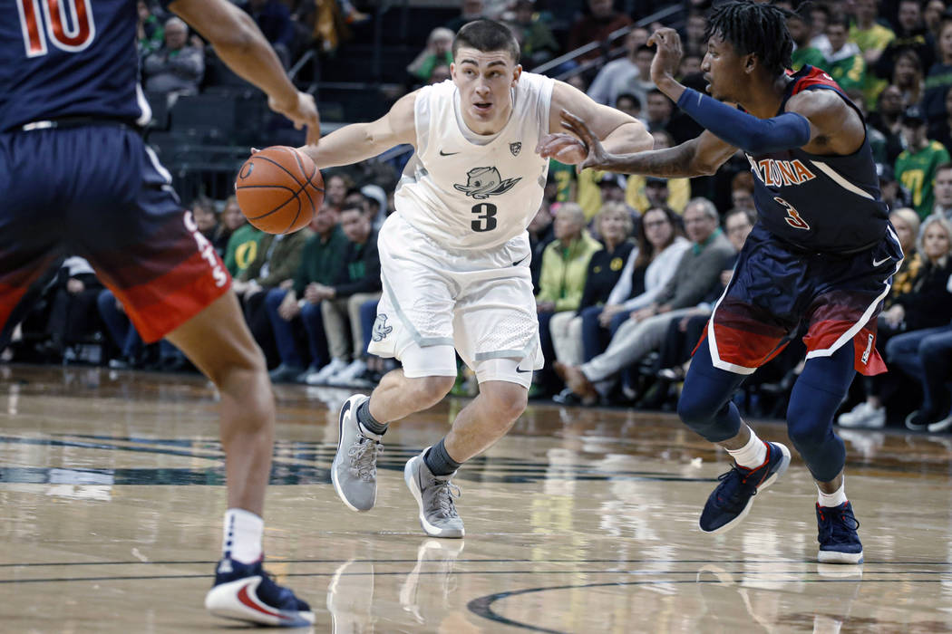 In this Jan. 9, 2020, file photo, Oregon's Payton Pritchard drives between Arizona defenders du ...