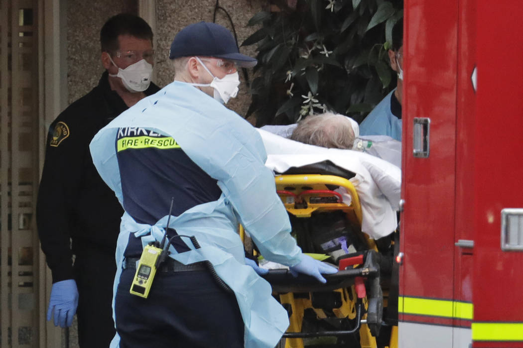 A patient is loaded into an ambulance, Tuesday, March 10, 2020, at the Life Care Center in Kirk ...