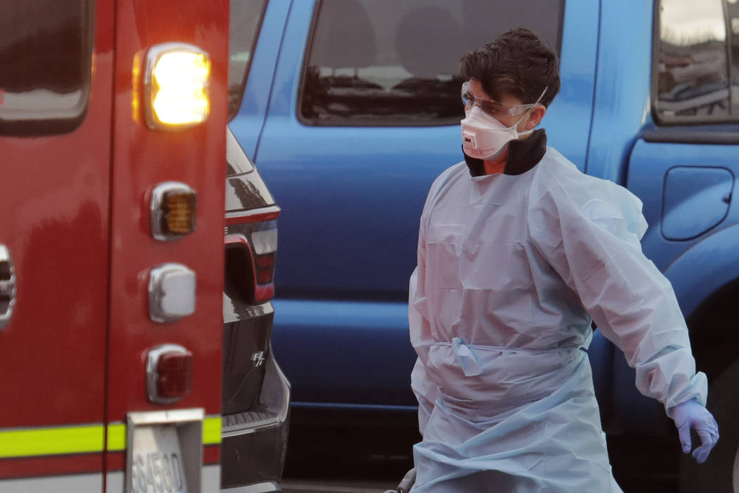 A Kirkland Fire and Rescue ambulance worker walks near a second ambulance after a patient was l ...