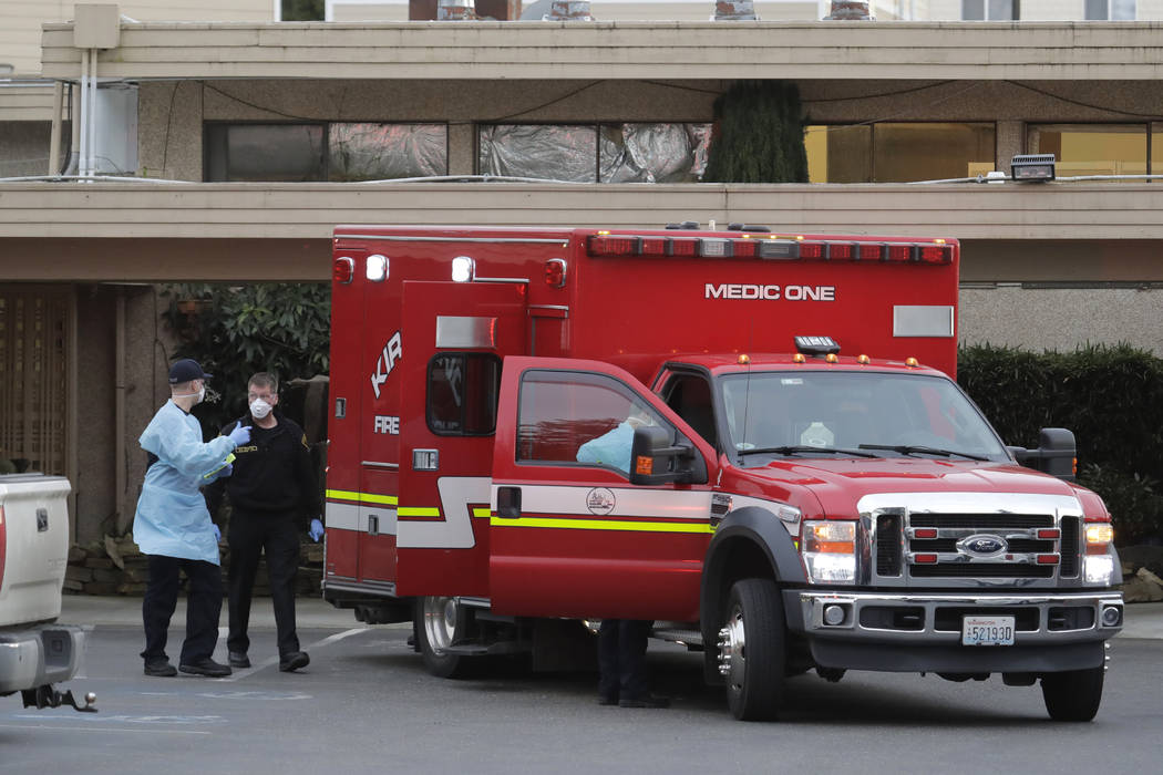 Kirkland Fire and Rescue ambulance workers walk near thier ambulance after a patient was loaded ...