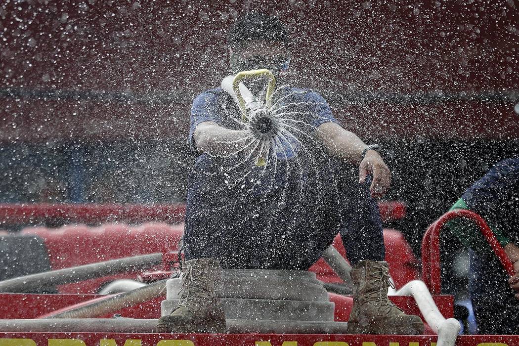 Firemen spray disinfectants outside a public market in Manila, Philippines on Wednesday, March ...