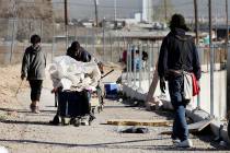 Individuals walk in a homeless community at the intersection of B Street and Owens Avenue in La ...