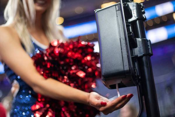 A University of Arizona cheerleader uses hand sanitizer after the game against University of Wa ...