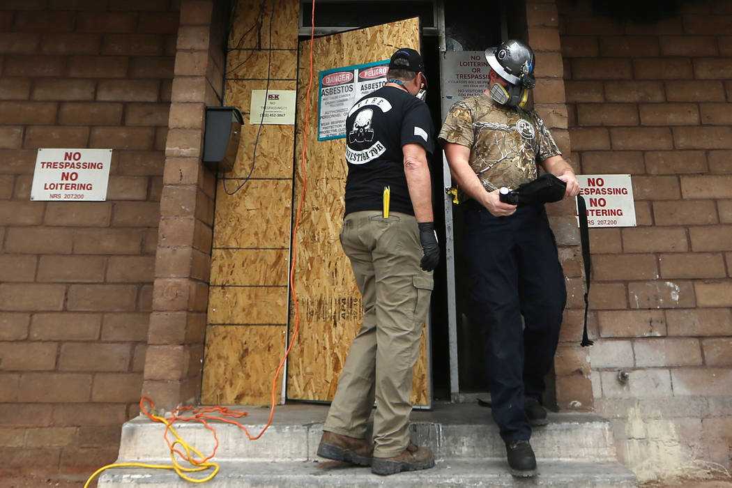 Employees with the Forensic Investigations Group work inside the Alpine Motel during an investi ...