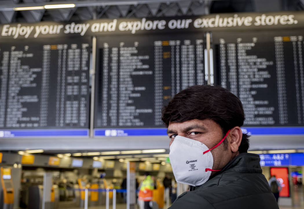 A passenger from India waits for his flight in a terminal at the airport in Frankfurt, Germany, ...