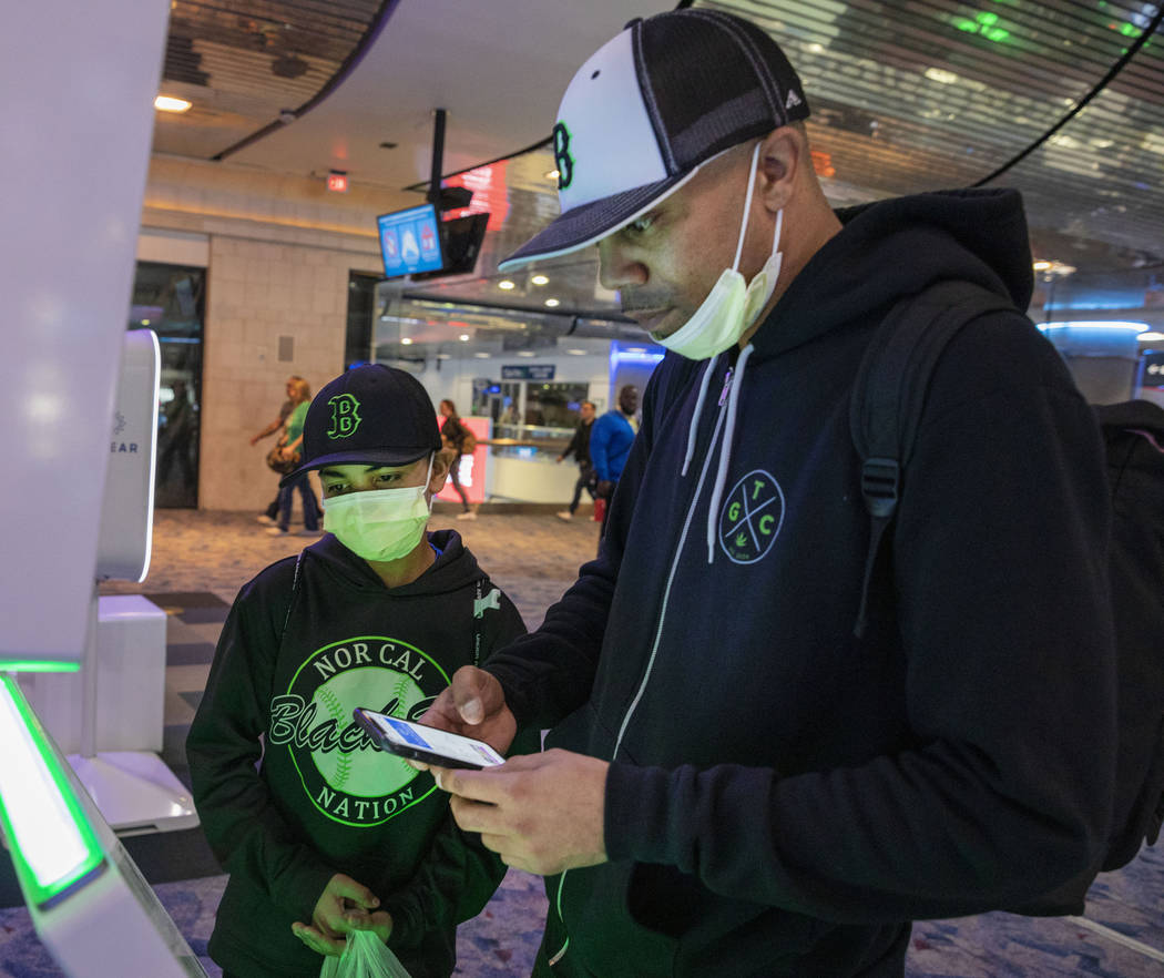 Christian Pabalate, 11, and his father, Nicholas Johnson, of San Francisco, print tickets durin ...