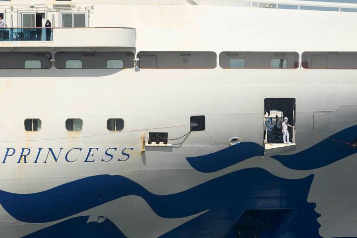 A crew member wears a mask while preparing to dock the Grand Princess in Oakland, Calif., Monda ...