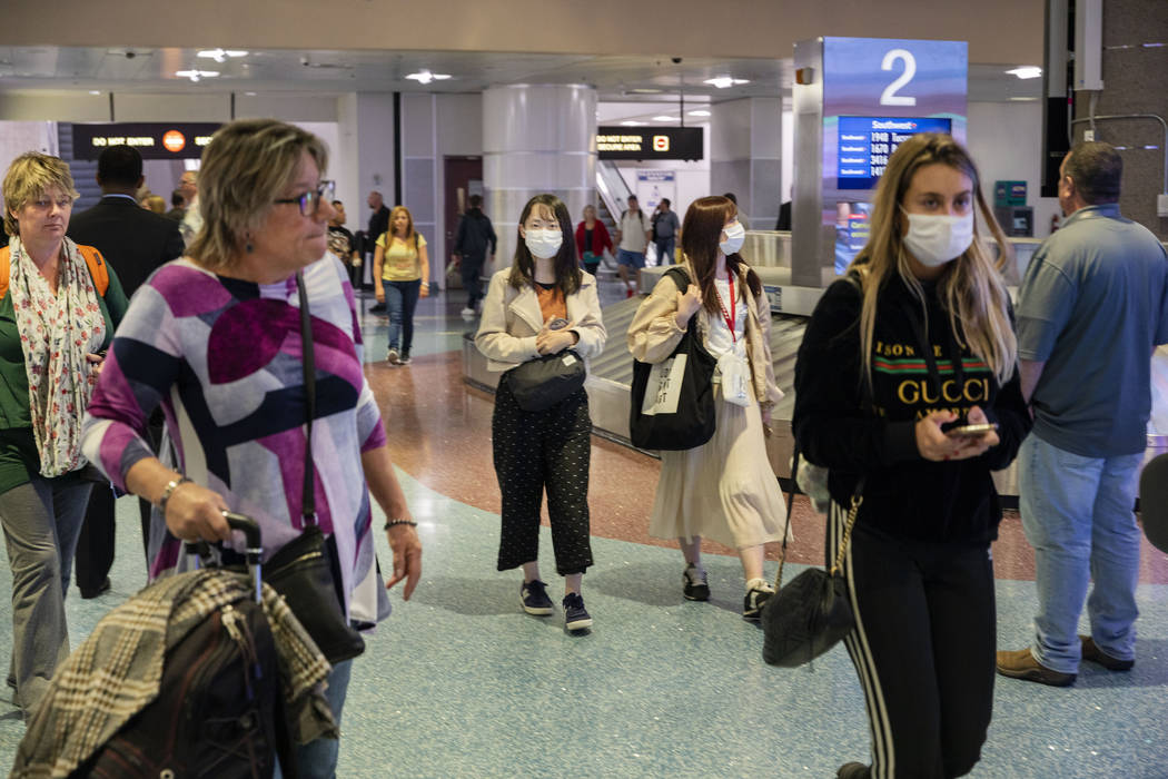 Passengers enter baggage claim at McCarran International Airport in Las Vegas on Thursday, Marc ...