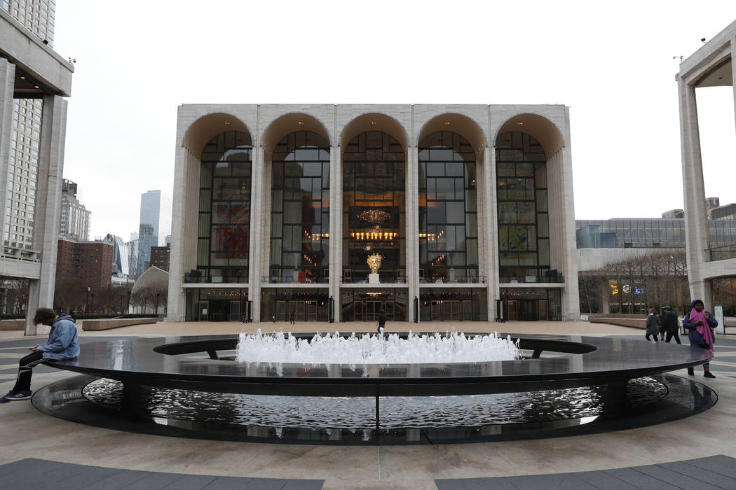 A handful of people pass through Josie Robertson Plaza in front of The Metropolitan Opera house ...