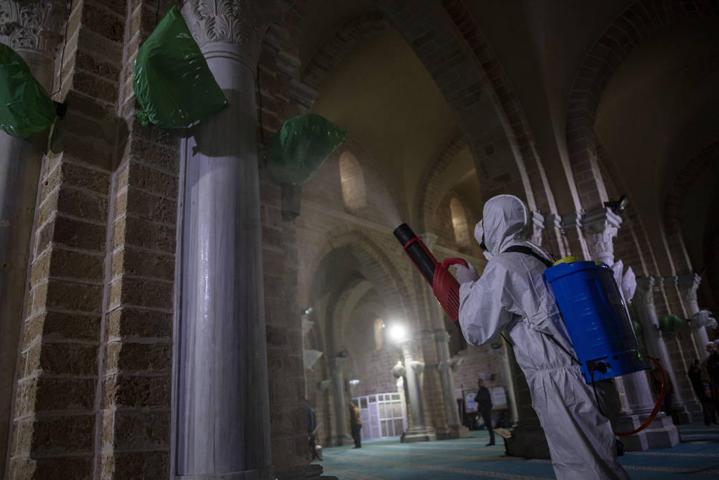 Palestinian Health workers spray disinfectant as a precaution against the new coronavirus in th ...