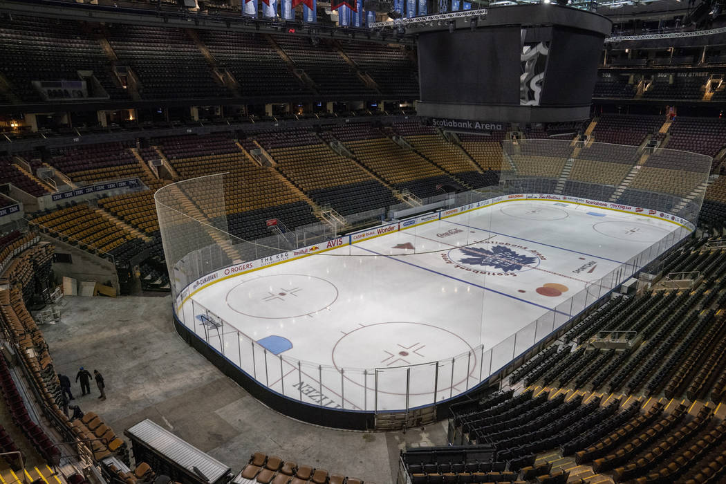 Workers stand by after pausing the assembly of the arena for the Maple Leafs NHL hockey game ag ...