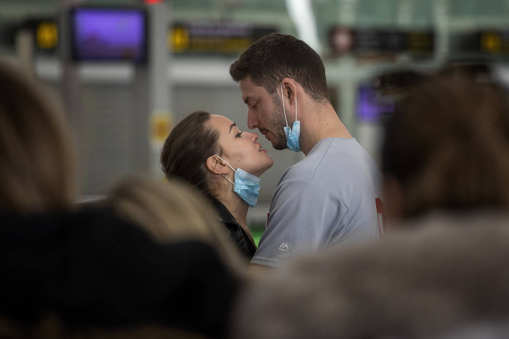 A couple kiss at the Barcelona Airport in Spain, Thursday, March 12, 2020. (AP Photo/Emilio Mor ...