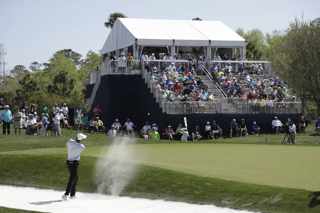 A small crowd watches Scottie Scheffler hit from the sand on the eighth hole, during the first ...