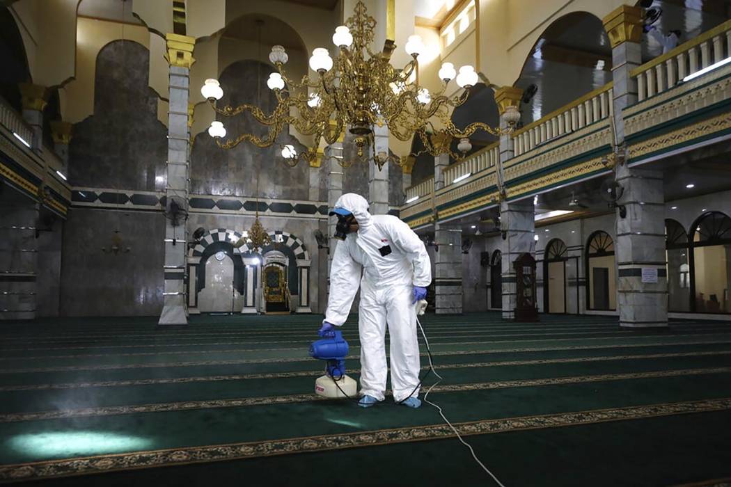 A health official sprays disinfectant in the wake of the new coronavirus outbreak ahead of the ...