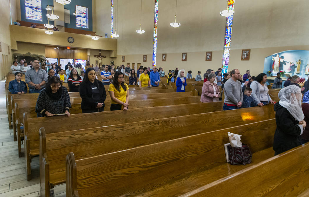 Parishioners pray during Sunday Mass at St. Anne's Catholic Church where they were asked to use ...
