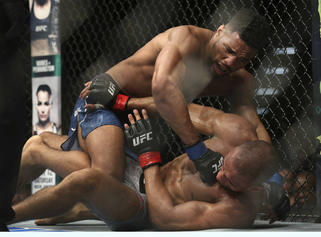 Edson Barboza, bottom, tries to protect himself as Kevin Lee hits him during the second round o ...