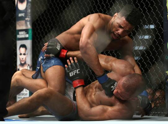 Edson Barboza, bottom, tries to protect himself as Kevin Lee hits him during the second round o ...