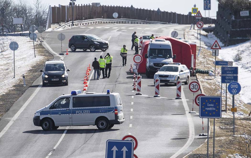 Czech policemen are standing on a street at the Czech border for entry control near Zinnwald, G ...