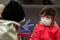 A woman plays with her daughter as they wait at Barcelona airport, Spain, Saturday, March 14, 2 ...