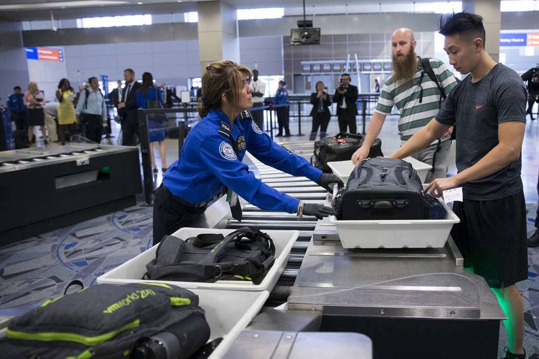 Transportation Security Administration agent Donna Franco, left, assists a passenger in one of ...