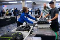 Transportation Security Administration agent Donna Franco, left, assists a passenger in one of ...