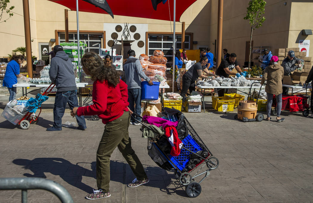 Staff and volunteers distribute food, water and supplies at SHARE Village Las Vegas on Saturday ...