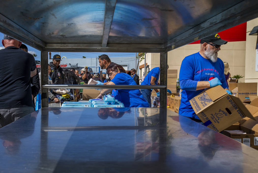 Staff and volunteers pass out food, water and supplies at SHARE Village Las Vegas on Saturday, ...