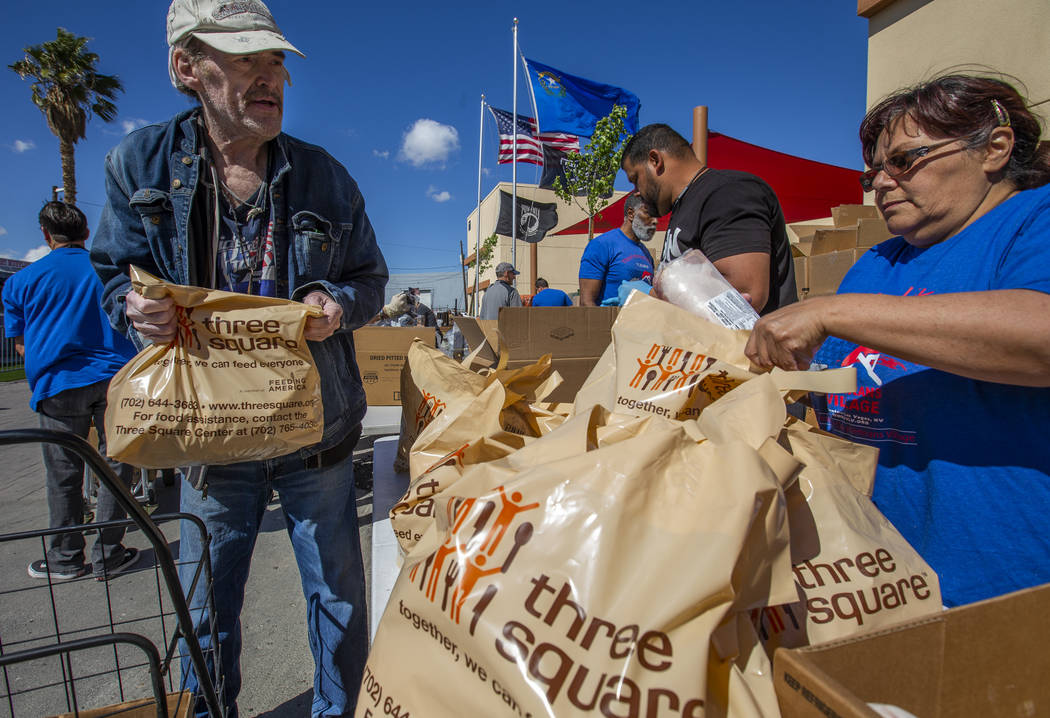 Staff and volunteers distribute food, water and supplies at SHARE Village Las Vegas on Saturday ...