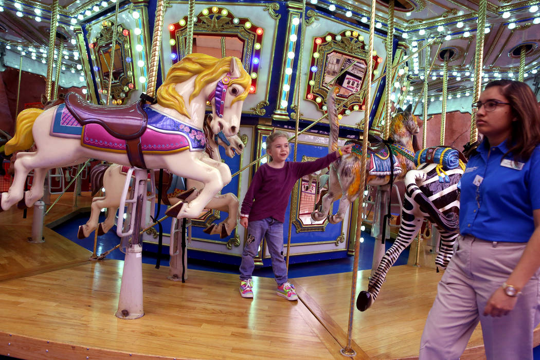 Abigail Forget, 7, of Canada picks her favorite horse on the carousel at Circus Circus Adventur ...