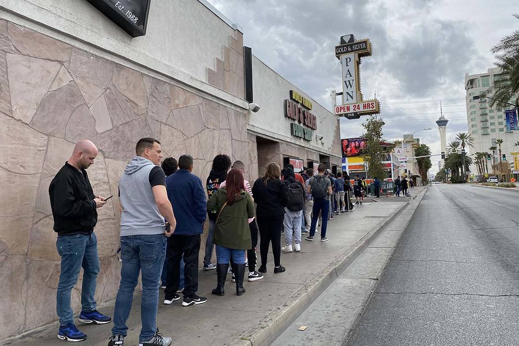 About two dozen people line up at Gold & Silver Pawn, made famous by the “Pawn Stars ...