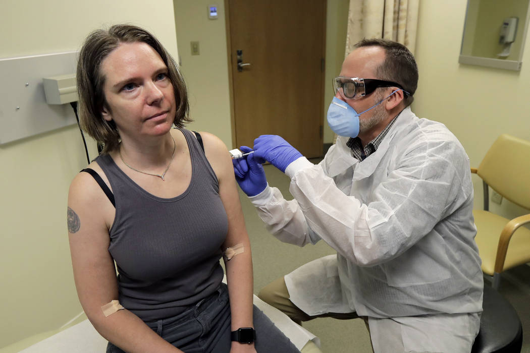 A pharmacist gives Jennifer Haller, left, the first shot in the first-stage safety study clinic ...