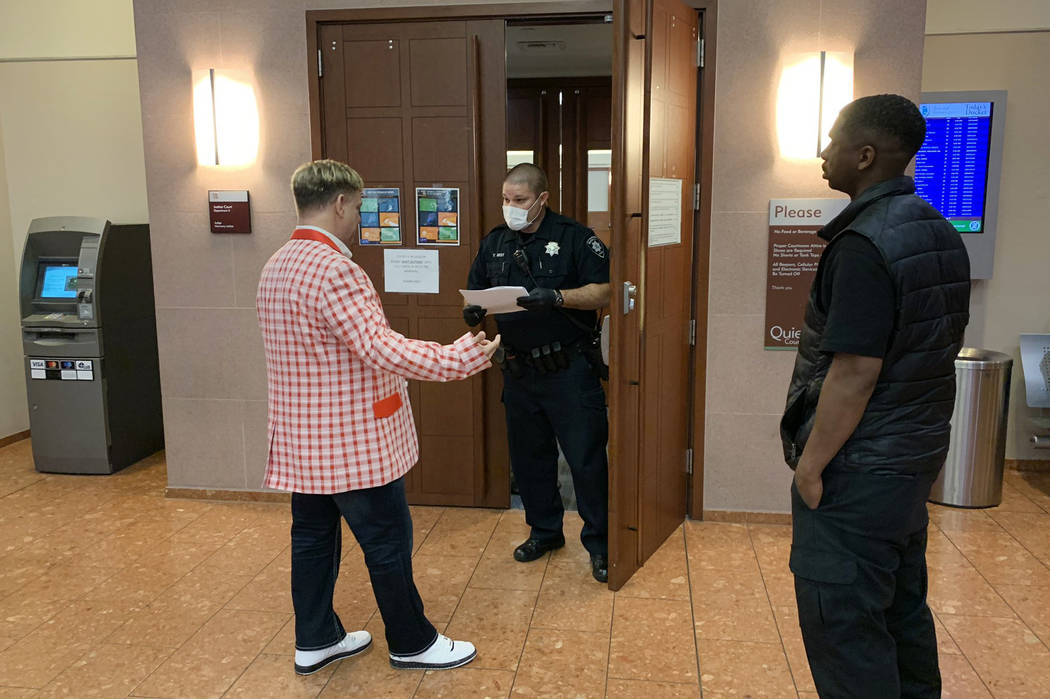 A Las Vegas Justice Court marshal at the Regional Justice Center helps a man inquiring about a ...