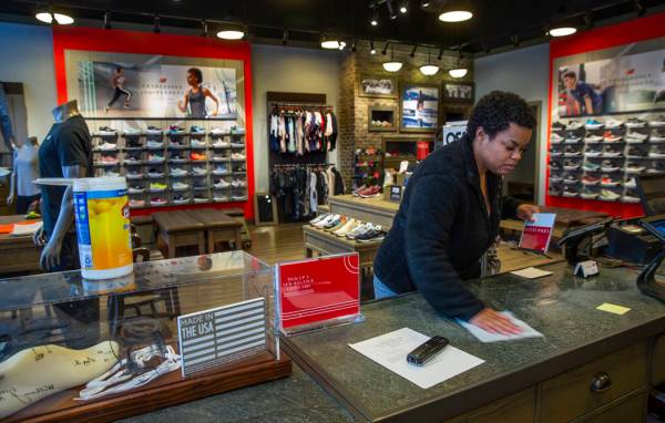 New Balance salesperson Heaven Fennell wipes down her counters and common areas at their Downto ...