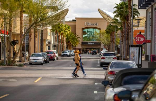 A few shoppers cross the street at Downtown Summerlin which has modified hours and some busines ...
