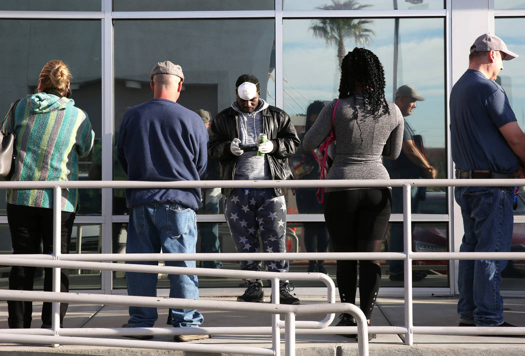 People wait in line at One-Stop Career Center on Monday, March 16, 2020, in Las Vegas. (Bizuaye ...