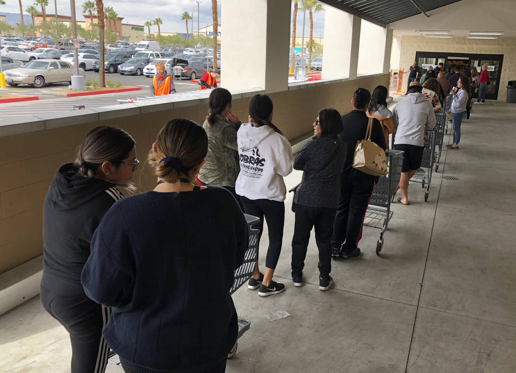 Customers wait in line at WinCo Foods on Monday, March 16, 2020, in Las Vegas. (Bizuayehu Tesfa ...