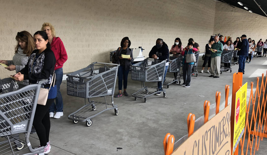 Customers wait in line at WinCo Foods on Monday, March 16, 2020, in Las Vegas. (Bizuayehu Tesfa ...