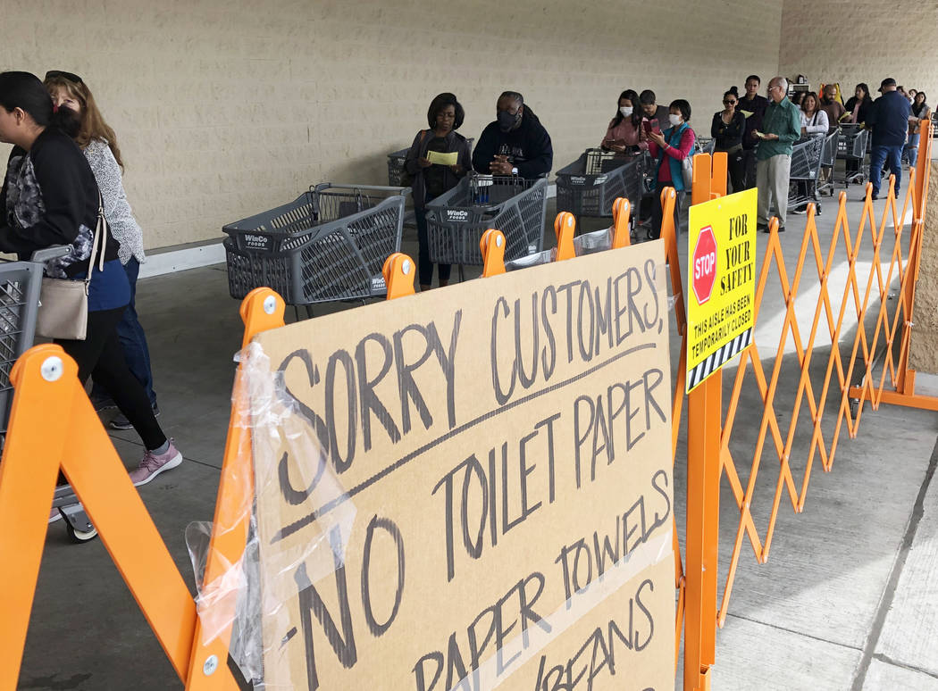 A list off sold out items are posted as customers wait in line at WinCo Foods on Monday, March ...