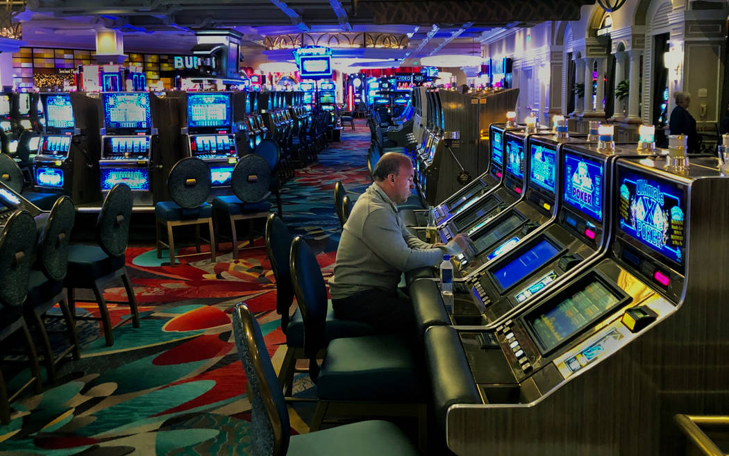 A lone electronic poker player remains before the Bellagio temporarily shuts down on Monday, Ma ...