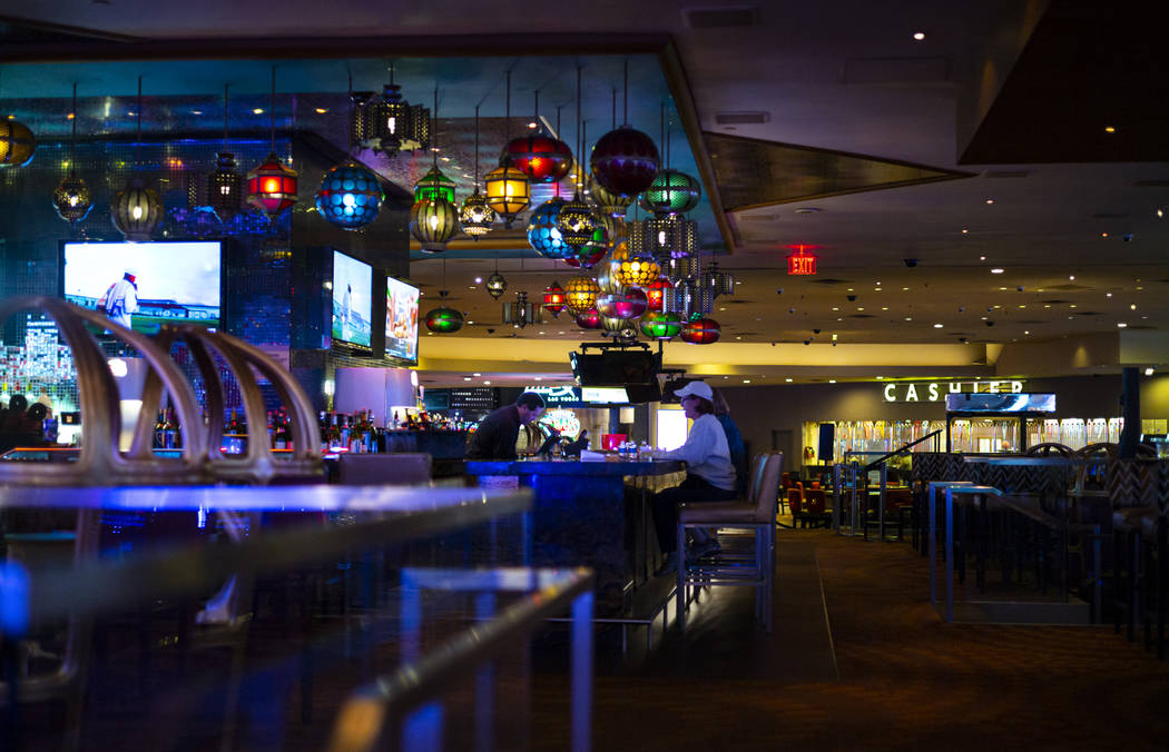 People drink at a bar shortly before the closure of the casino at the Luxor in Las Vegas on Mon ...