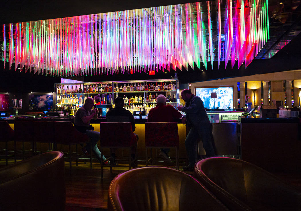 People drink at a bar shortly before the closure of the casino at the Luxor in Las Vegas on Mon ...