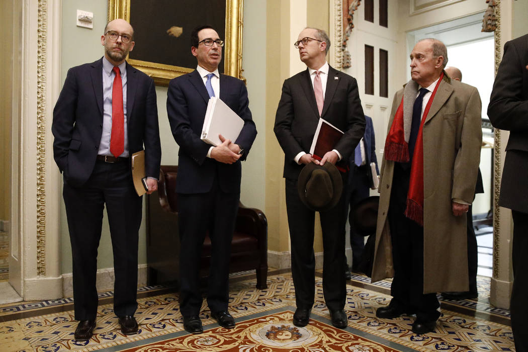 Treasury Secretary Steve Mnuchin, second from left, speaks with members of the media as he depa ...