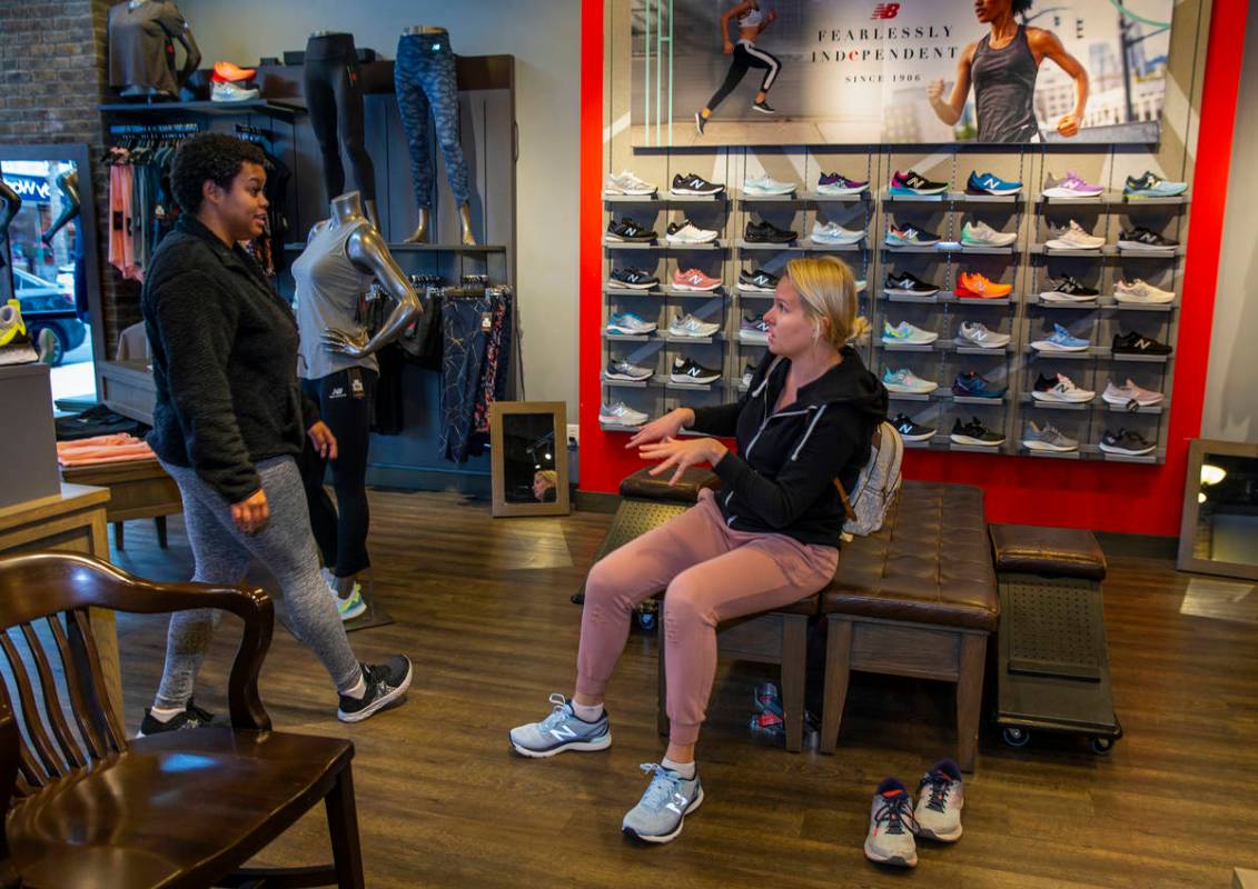 New Balance salesperson Heaven Fennell, left, works with customer Sandra Rivers at their Downto ...