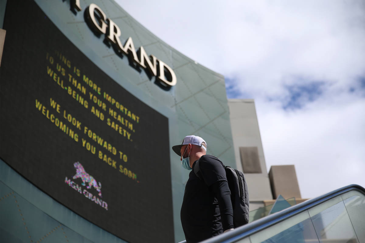 A person wearing a mask rides the escalator across from the MGM Grand casino-hotel in Las Vegas ...