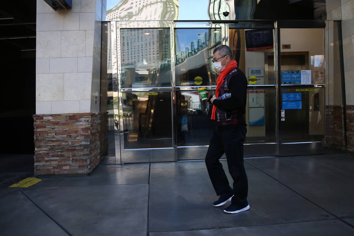 A person walks wearing a mask on the Strip in Las Vegas, Tuesday, March 17, 2020. (Erik Verduzc ...