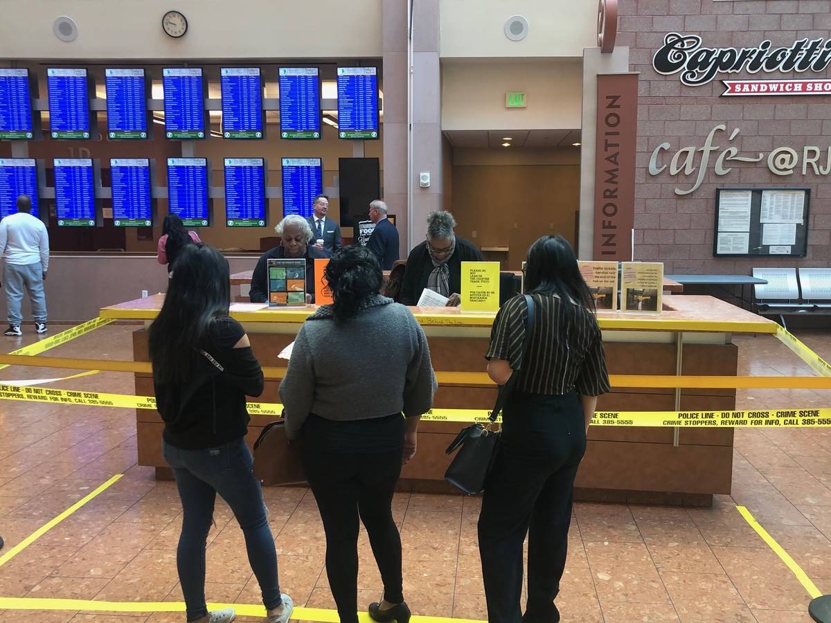 Courthouse visitors stand behind police tape around the information desk at the Regional Justic ...